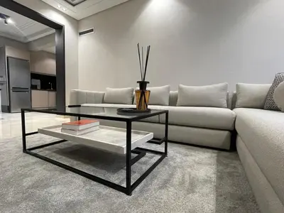 a living room with a couch and a glass coffee table at Studio Chic proche Twins Center in Casablanca
