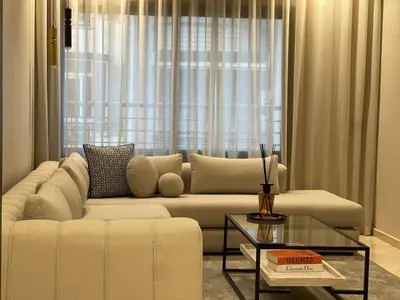 a living room with a white couch and a glass table at Studio Chic proche Twins Center in Casablanca