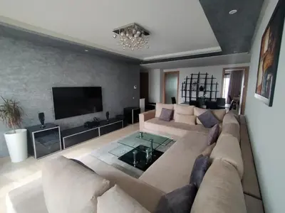 a large living room with a couch and a tv at Prestigia Luxurious 3BR 5 min walk from stadium in Rabat