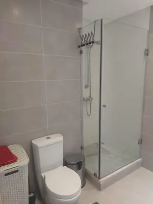 a bathroom with a toilet and a glass shower at Prestigia Luxurious 3BR 5 min walk from stadium in Rabat