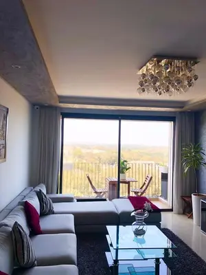 a living room with a couch and a large window at Prestigia Luxurious 3BR 5 min walk from stadium in Rabat