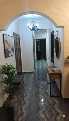 a hallway with a table and a chair in a room at Appartement dans le centre de la plage de av Tantan in Casablanca