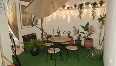 a patio with a table and chairs and potted plants at Appartement dans le centre de la plage de av Tantan in Casablanca