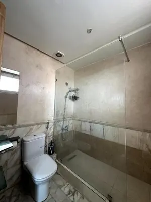 a bathroom with a toilet and a shower and a tub at La Perle Aïn Diab Beachfront in Casablanca