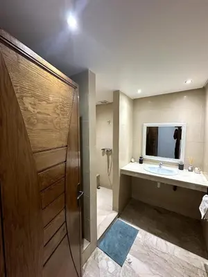a bathroom with a sink and a shower with a mirror at La Perle Aïn Diab Beachfront in Casablanca