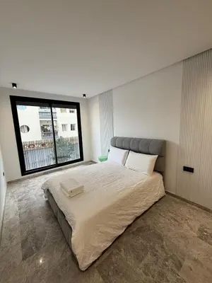 a bedroom with a large bed with a large window at 2 bedrooms in the heart of Casablanca in Casablanca