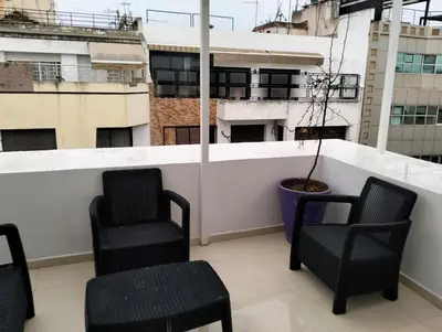 a balcony with two chairs and a potted plant at Luxury Apartment Agdal, Ideal for CAN 2025 Fans in Rabat