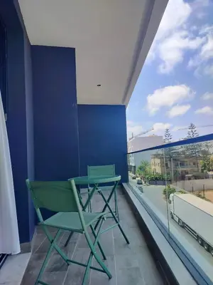 a green chair on a balcony with a large window at Luxury Stay in Casablanca in Maarif