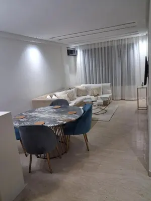 a living room with a table and a couch at Moderne Studio En plein quartier Maârif avec wifi, balcon,parking et trés bon emplacement in Casablanca