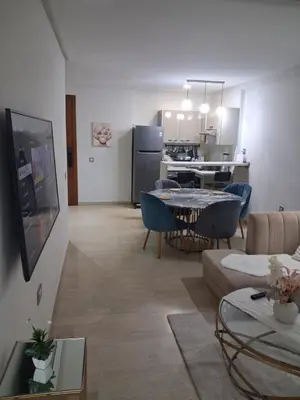 a living room with a table and a kitchen at Moderne Studio En plein quartier Maârif avec wifi, balcon,parking et trés bon emplacement in Casablanca