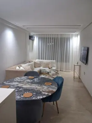 a living room with a table and a couch at Moderne Studio En plein quartier Maârif avec wifi, balcon,parking et trés bon emplacement in Casablanca