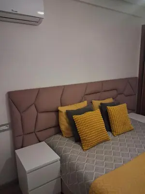 a bed with yellow and black pillows on it at Moderne Studio En plein quartier Maârif avec wifi, balcon,parking et trés bon emplacement in Casablanca