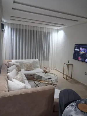 a living room with a couch and a glass table at Moderne Studio En plein quartier Maârif avec wifi, balcon,parking et trés bon emplacement in Casablanca