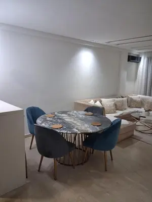 a living room with a table and chairs and a couch at Moderne Studio En plein quartier Maârif avec wifi, balcon,parking et trés bon emplacement in Casablanca