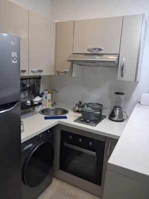 a small kitchen with a stove and a sink at Moderne Studio En plein quartier Maârif avec wifi, balcon,parking et trés bon emplacement in Casablanca