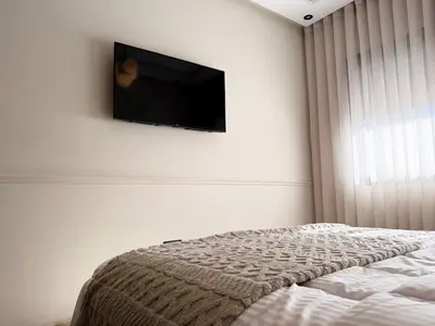 a bedroom with a flat screen tv on the wall at Zenata Luxury Stay in Aïn Harrouda