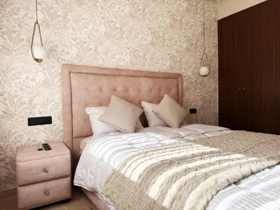 a bedroom with a large bed and a night stand at Zenata Luxury Stay in Aïn Harrouda