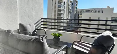 a person sitting in a chair on a balcony at Zenata Luxury Stay in Aïn Harrouda