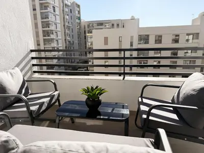 a balcony with chairs and a vase on a table at Zenata Luxury Stay in Aïn Harrouda