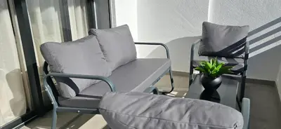 two chairs and a table with a pillow on a balcony at Zenata Luxury Stay in Aïn Harrouda