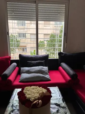 a living room with a red couch with a large window at Cozy & calm in Bouznika