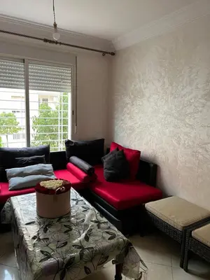 a living room with a red couch and a table at Cozy & calm in Bouznika