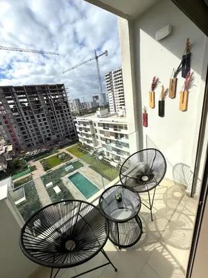 a balcony with three chairs and tables on a building at VIVASTAY Casablanca - Zenata eco city beach access with swimming pool in Aïn Harrouda