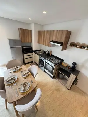 a kitchen with a table and chairs and a stove at VIVASTAY Casablanca - Zenata eco city beach access with swimming pool in Aïn Harrouda