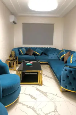 a living room with blue couches and a table at Najia Blue Pearl in Sidi Rahal