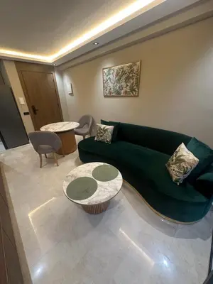a living room with a green couch and two tables at Studio Neuf in Casablanca