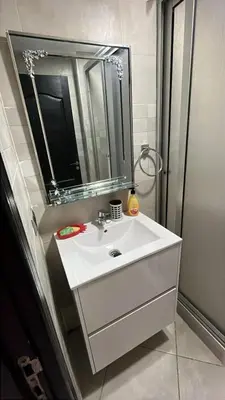 a bathroom with a white sink and a mirror at Appartement duplexe convivial in Bouznika