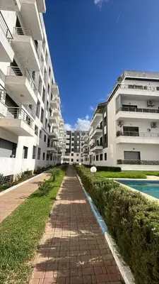 an empty sidewalk in front of some apartment buildings at Appartement duplexe convivial in Bouznika
