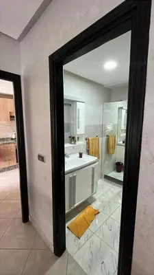 a bathroom with a sink and a mirror at Appartement duplexe convivial in Bouznika