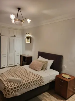 a bedroom with a bed and a table and a chandelier at Appartement chic de 3 chambres au cœur de Casablanca in Casablanca