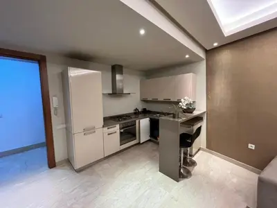 a kitchen with a refrigerator and a counter top at residence socrate in Casablanca