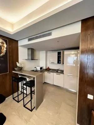a kitchen with a island with two bar stools at residence socrate in Casablanca