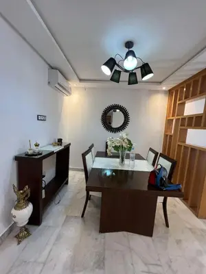 a dining room with a table and a mirror at Appartement confortable in Maarif