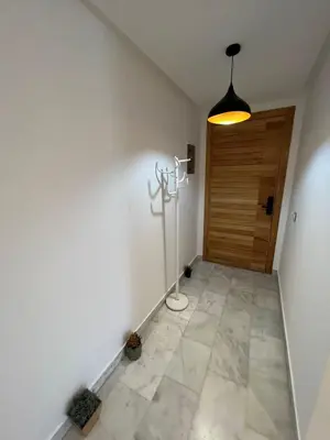 a hallway with a door and a light on the wall at Appartement confortable in Maarif