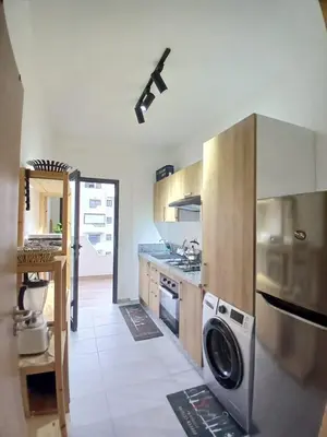 a kitchen with a washer and dryer in it at Cozy 2-bedroom apartment, pool view with beach access a Zenata City Eco Casablanca in Oulad Akkou