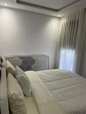a bed with white sheets and pillows in a bedroom at Studio Les princesses in Maarif