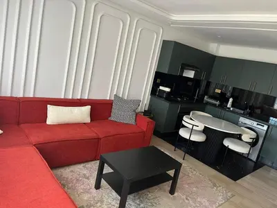a living room with a red couch and a table at Studio Les princesses in Maarif