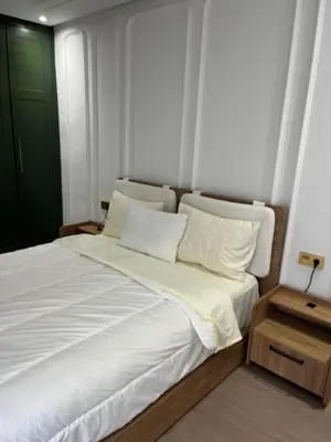 a bedroom with a white bed with a green door at Studio Les princesses in Maarif