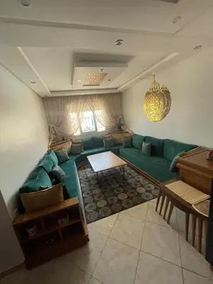 a living room with a green couch and a table at relaxing apartment in Bouznika in Bouznika