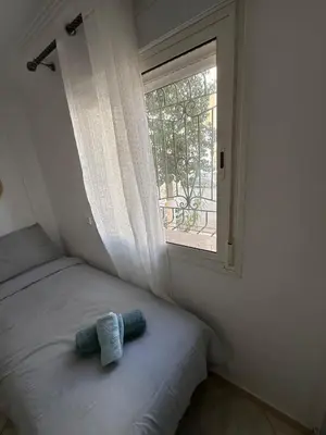 a stuffed animal sitting on a bed next to a window at relaxing apartment in Bouznika in Bouznika
