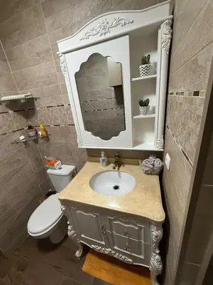 a bathroom with a sink and a toilet and a mirror at relaxing apartment in Bouznika in Bouznika