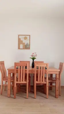a wooden dining table and chairs with a vase on it at T3 Moderne proche Ocean in Rabat