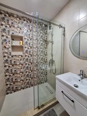 a bathroom with a glass shower and a sink at T3 Moderne proche Ocean in Rabat