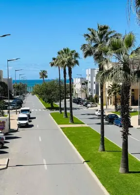 a city street with palm trees and the ocean at T3 Moderne proche Ocean in Rabat