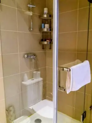 a bathroom with a shower with a toilet and a towel at Moroccan Sunset - Charming 3BR near Airport Med 5 in Nouaseur