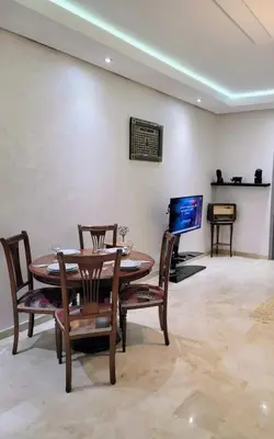 a dining room with a table and chairs and a tv at Moroccan Sunset - Charming 3BR near Airport Med 5 in Nouaseur